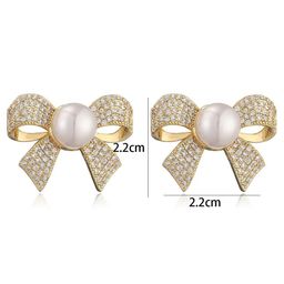 Celestique Cubic Zirconia & Pearls Studded Bow Shaped Studs image 2