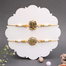 Myntra Elegant Homes Set Of 2 Gold Symbol Beaded Rakhis With Greeting Card & Roli Chawal-55